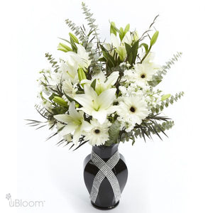 Black vase of royal lilies, gerbera and spray stock, agonis, and eucalyptus