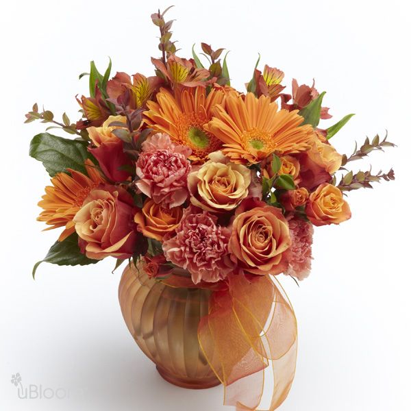 Floral arrangement in a bronze vase with spray rose, carnations, alstroemeria, gerbera and roses