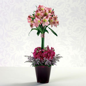 Elegant floral arrangement featuring wired alstroemeria above a bed of Limonium and purple stock.